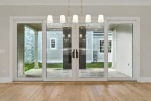 Sliding glass door leading to backyard with outdoor patio and neighboring home in view.