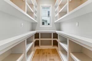 Bright walk-in closet with built-in shelves and natural light.