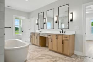 Bathroom featuring double vanity, mirrors, and bathtub at 11726 Sweetflag Circle.