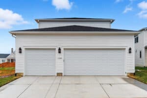 A clean, white garage with double doors and house number 11524.