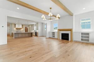 Spacious living area with hardwood floors, fireplace, and large windows.
