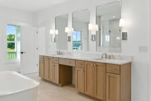 Bathroom with double vanity, mirrors, and natural light.